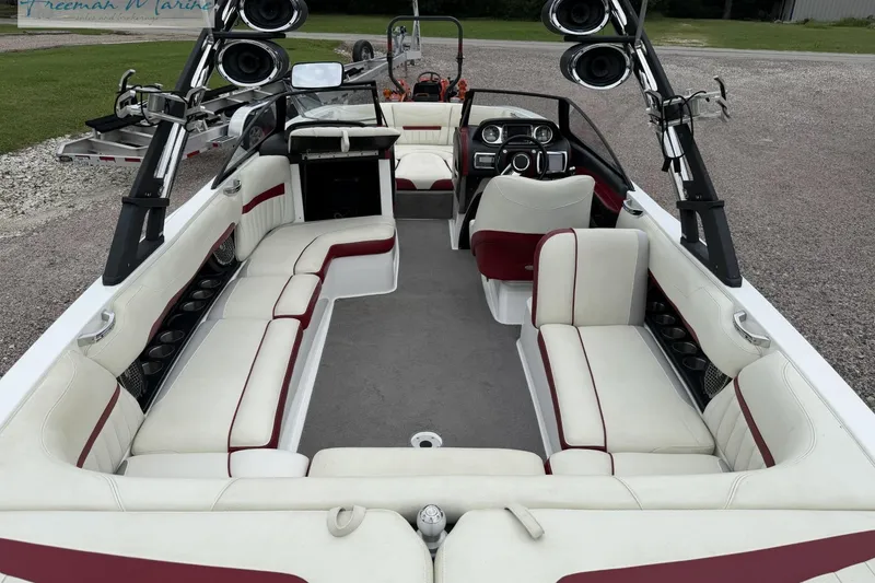 Slide: The Image of 2014 Malibu Wakesetter 24 MXZ boat interior with white and red seating, speakers, and steering console. - 38
