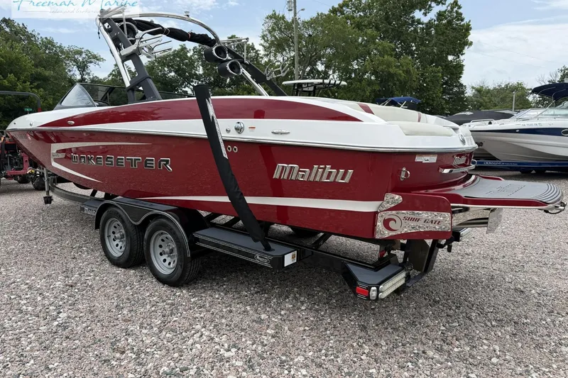 Slide: The Image of 2014 Malibu Wakesetter 24 MXZ boat in red and white on a trailer. - 3
