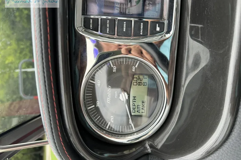 Slide: The Image of Dashboard of a 2014 Malibu Wakesetter 24 MXZ boat showing speedometer and temperature gauges. - 35