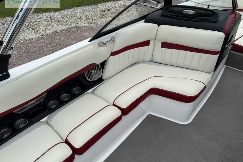 Slide: The Image of 2014 Malibu Wakesetter 24 MXZ interior with white and red seating, cup holders, and speaker. - 25
