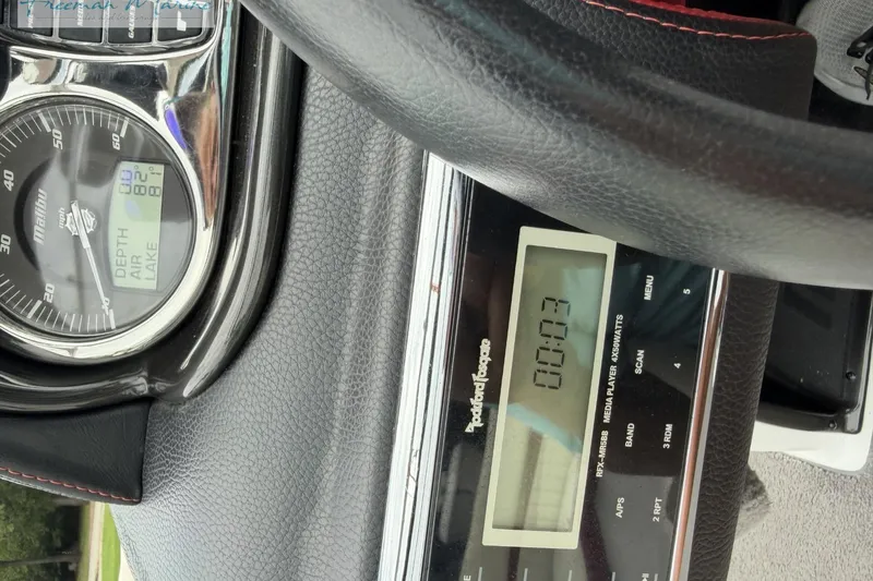 Slide: The Image of Dashboard of a 2014 Malibu Wakesetter 24 MXZ boat with gauges and controls. - 37