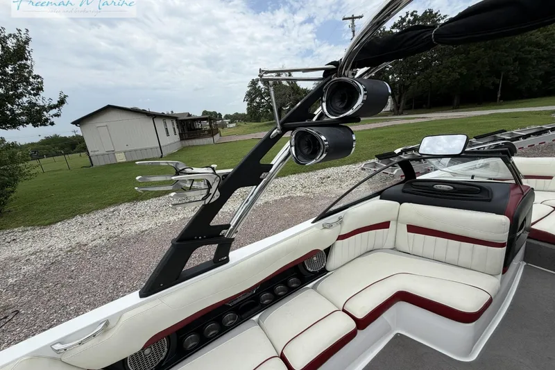 Slide: The Image of 2014 Malibu Wakesetter 24 MXZ boat interior with white and red seating, speakers, and wakeboard rack. - 23