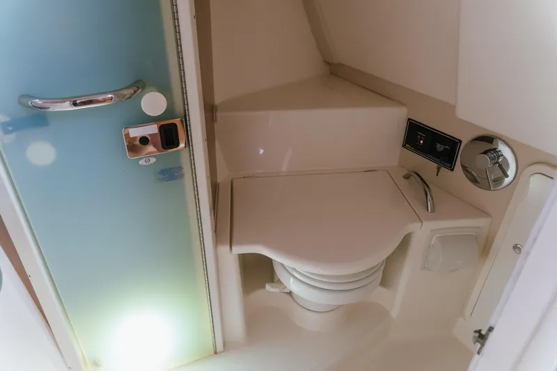 Slide: The Image of 2013 Pursuit OS 345 Offshore boat bathroom with compact toilet and modern fixtures. - 13