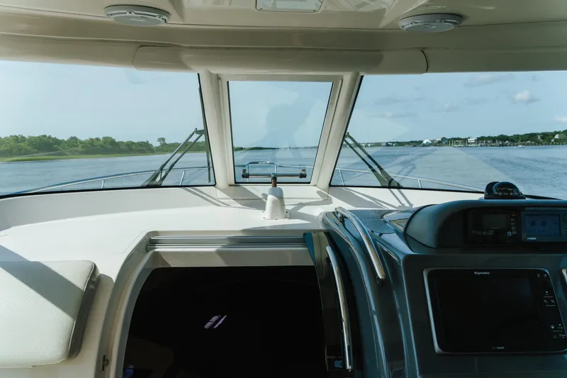 Slide: The Image of Interior view of 2013 Pursuit OS 345 Offshore boat cockpit, navigating calm waters. - 10