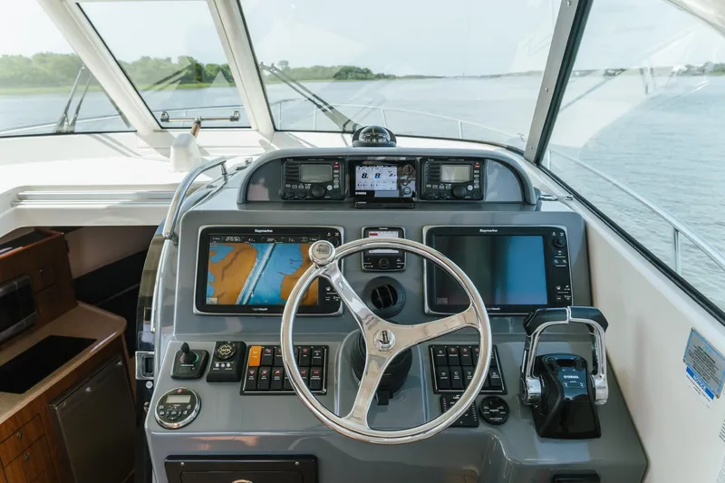 Slide: The Image of Helm of 2013 Pursuit OS 345 Offshore boat with navigation equipment and steering wheel. - 5