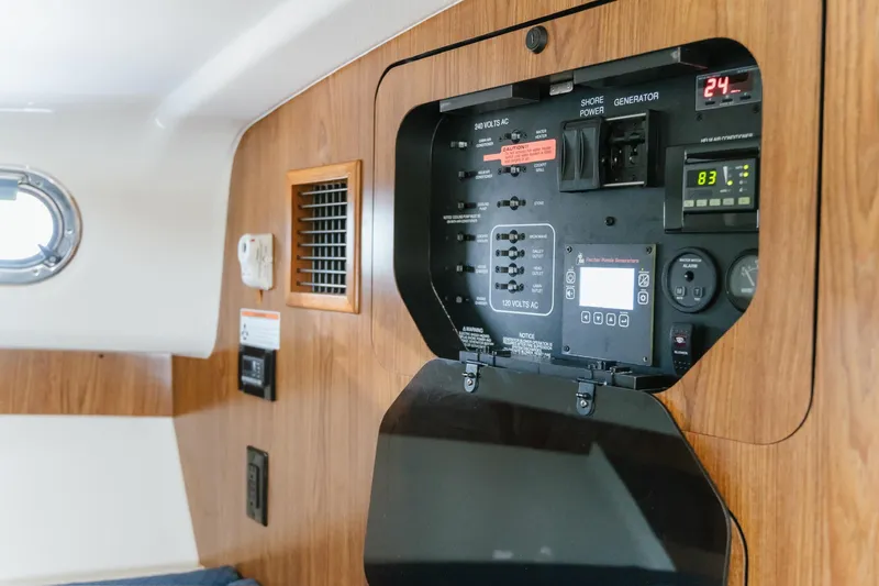 Slide: The Image of Control panel inside 2013 Pursuit OS 345 Offshore boat, featuring electrical switches and gauges. - 14