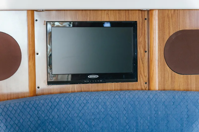 Slide: The Image of Flat-screen TV on 2013 Pursuit OS 345 Offshore boat, mounted on wooden paneling. - 16