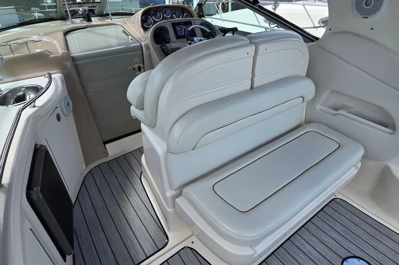 Slide: The Image of Interior of a 2002 Sea Ray 300 Sundancer boat with white seating and control panel. - 9