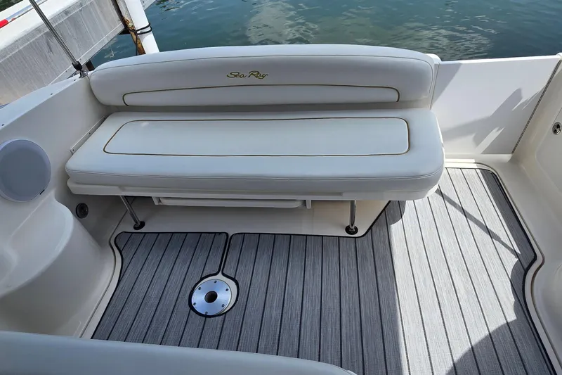 Slide: The Image of 2002 Sea Ray 300 Sundancer boat interior with cushioned seating and striped flooring. - 10