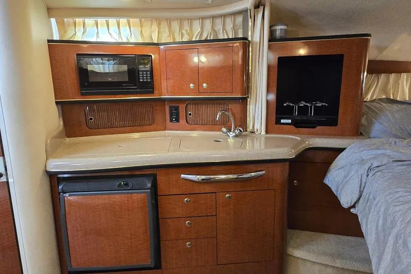 Slide: The Image of Interior of 2002 Sea Ray 300 Sundancer yacht with kitchenette and wood cabinetry. - 20