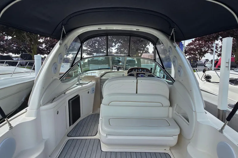Slide: The Image of 2002 Sea Ray 300 Sundancer boat interior with white seating and dashboard view. - 7