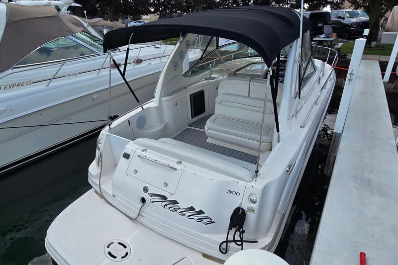 Slide: The Image of 2002 Sea Ray 300 Sundancer boat docked, featuring sleek design and spacious seating. - 5