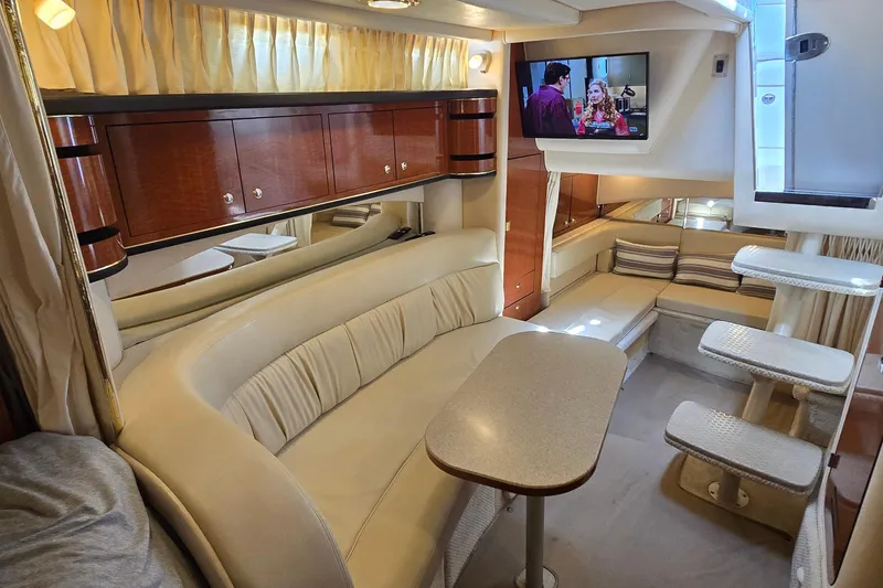 Slide: The Image of Luxurious interior of a 2002 Sea Ray 300 Sundancer yacht with cozy seating and TV. - 19