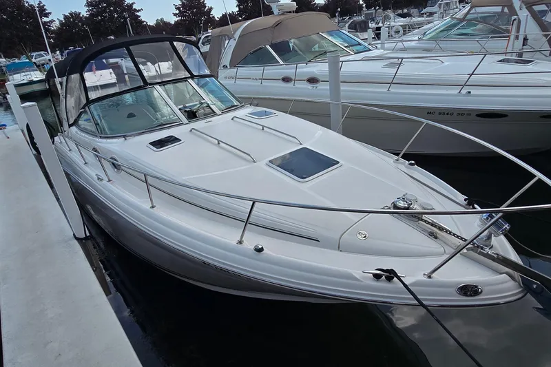 Slide: The Image of 2002 Sea Ray 300 Sundancer docked at marina, featuring sleek design and spacious deck. - 4