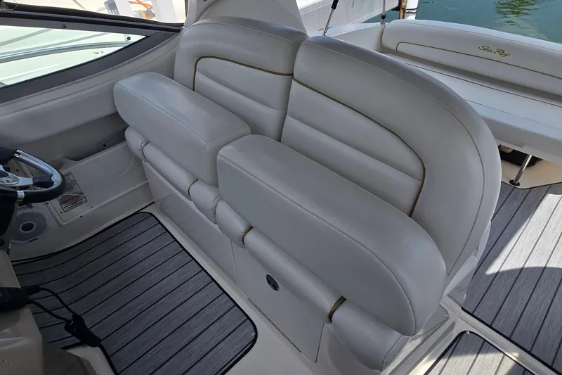 Slide: The Image of 2002 Sea Ray 300 Sundancer interior with plush seating and steering wheel. - 16