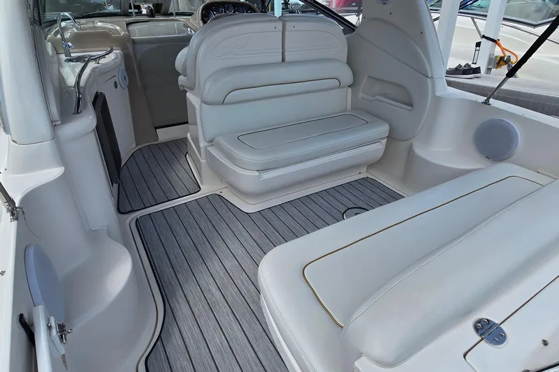 Slide: The Image of Interior of a 2002 Sea Ray 300 Sundancer boat with white seating and gray flooring. - 8