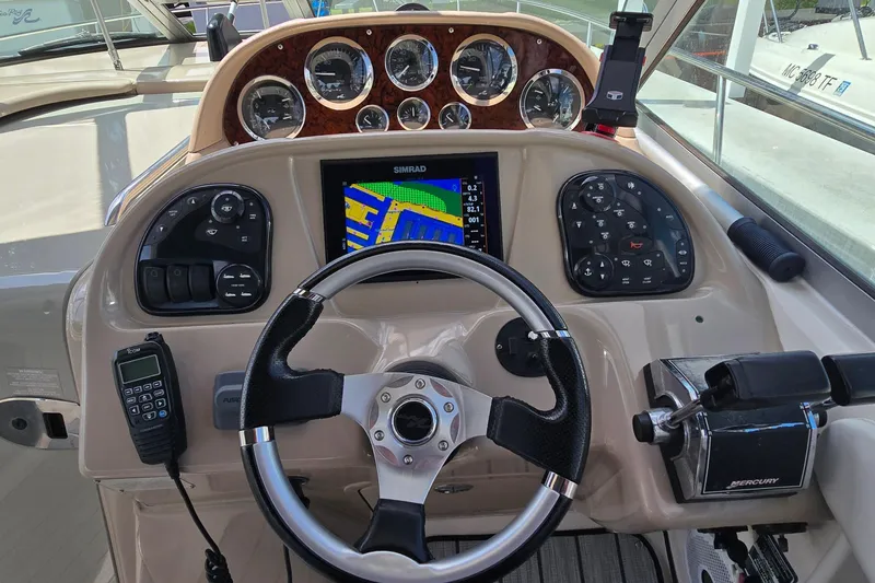 Slide: The Image of Helm of 2002 Sea Ray 300 Sundancer with navigation system and controls. - 14