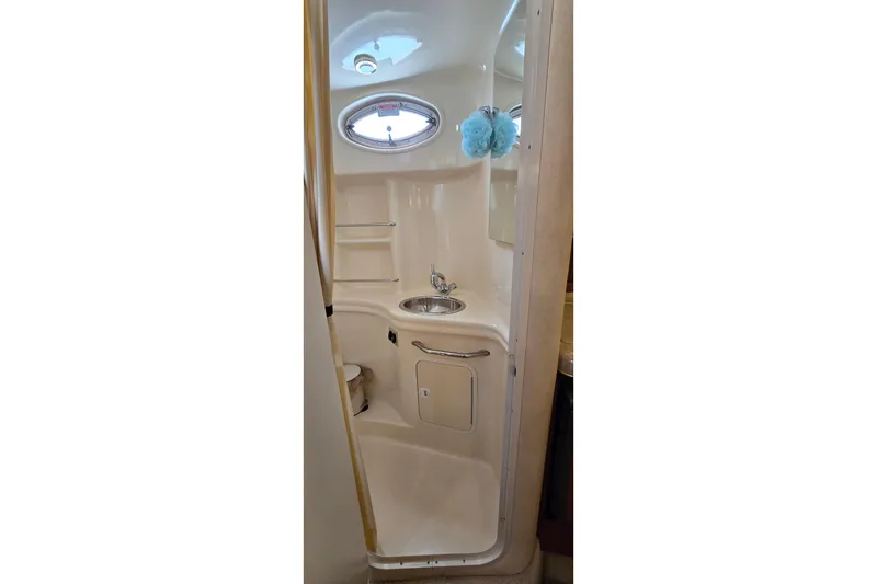 Slide: The Image of Compact bathroom in 2002 Sea Ray 300 Sundancer yacht, featuring sink and storage. - 25