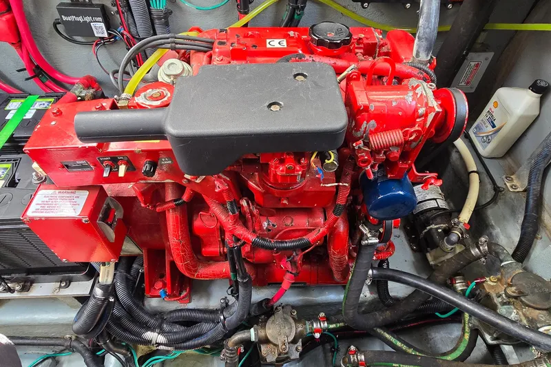 Slide: The Image of Engine compartment of a 2002 Sea Ray 300 Sundancer with red engine components. - 34