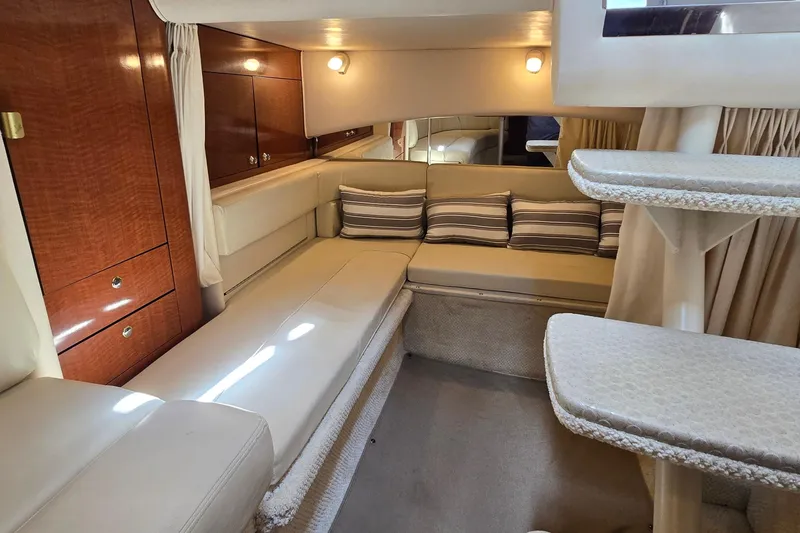 Slide: The Image of Luxurious interior of 2002 Sea Ray 300 Sundancer with plush seating and elegant wood cabinetry. - 21