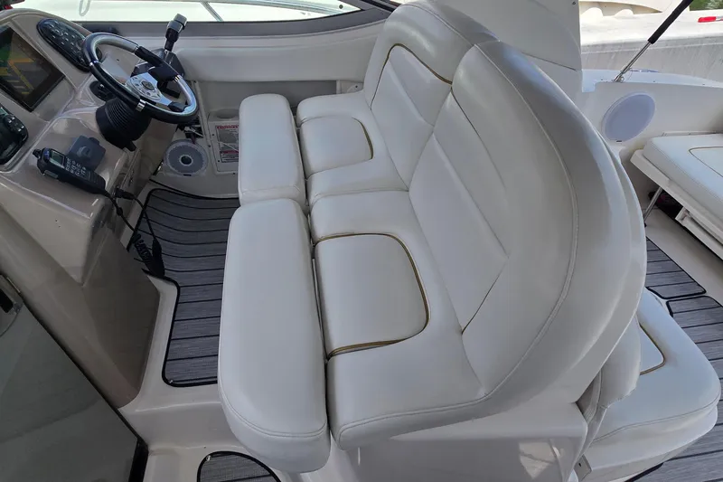 Slide: The Image of 2002 Sea Ray 300 Sundancer cockpit with white leather seating and steering console. - 15