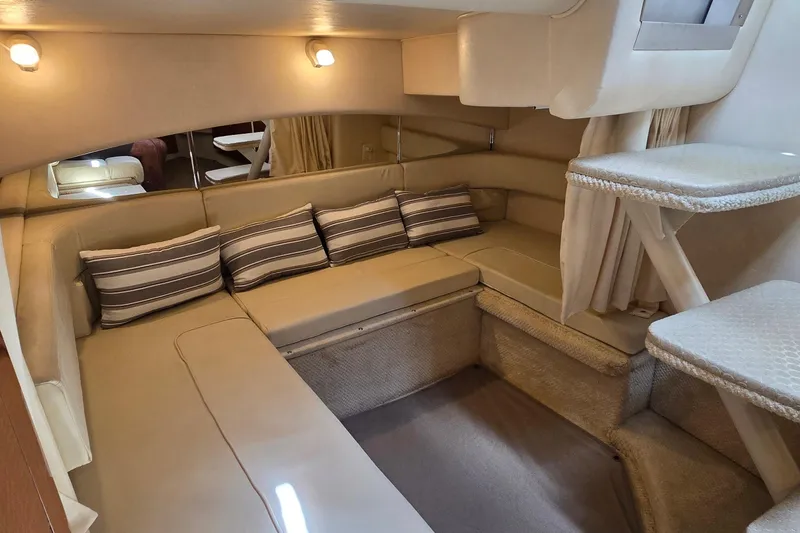 Slide: The Image of Interior of 2002 Sea Ray 300 Sundancer with cozy seating and striped cushions. - 22