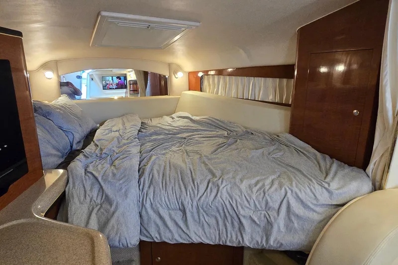 Slide: The Image of Interior cabin of 2002 Sea Ray 300 Sundancer with cozy bed and wooden accents. - 18