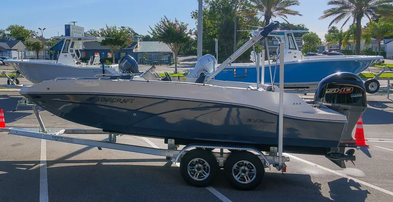 Slide: The Image of A 2027 Starcraft SVX 211 OB boat on a trailer, parked in a lot. - 5