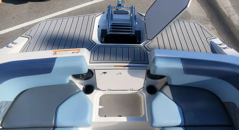 Slide: The Image of The image shows the stern of a Starcraft SVX 211 OB boat with blue seating and storage. - 20