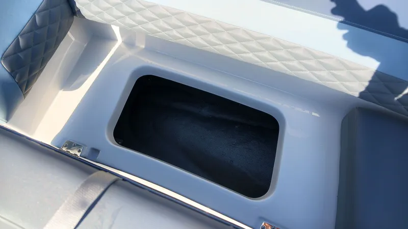 Slide: The Image of An open storage compartment on a boat with cushioned seating. - 18