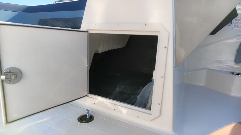 Slide: The Image of An open storage compartment on a boat with a white interior. - 21