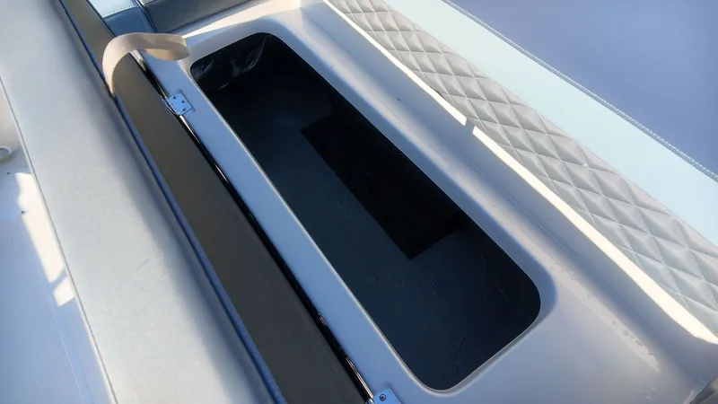 Slide: The Image of An open storage compartment on a boat with cushioned seats and diamond pattern. - 11