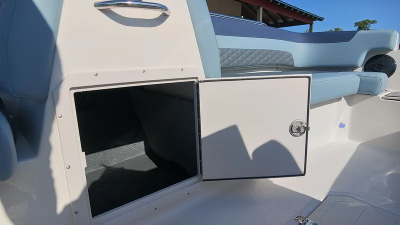 Slide: The Image of An open storage compartment on a boat with blue and white seating. - 13