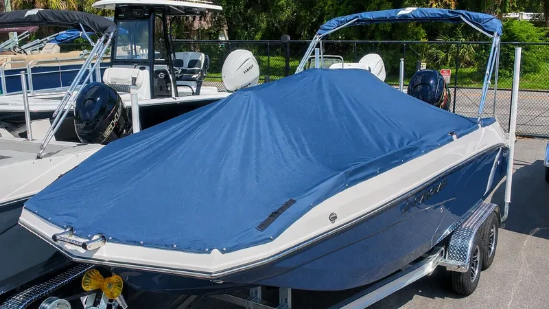 Slide: The Image of A 2027 Starcraft SVX 211 OB boat with a blue cover on a trailer. - 24