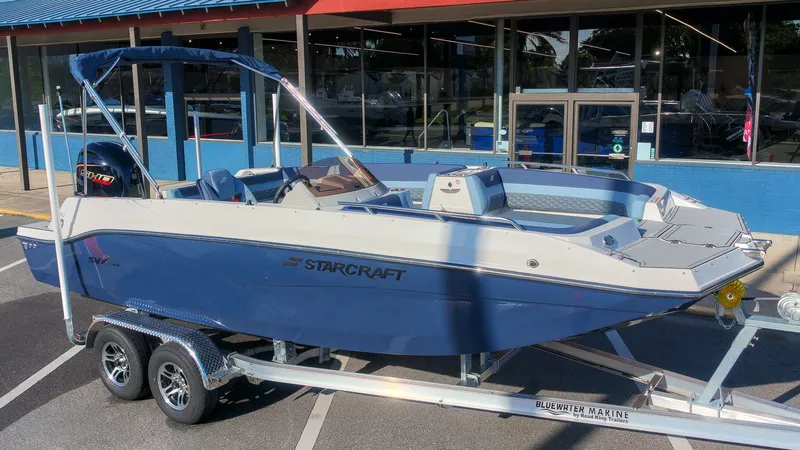 The Image of Starcraft SVX 211 OB 2027 on a trailer in front of a blue building. - 1