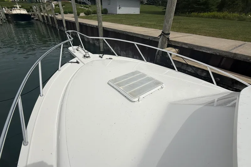 Slide: The Image of 1999 Blackfin 33 Flybridge boat docked, showcasing bow and railing details. - 18
