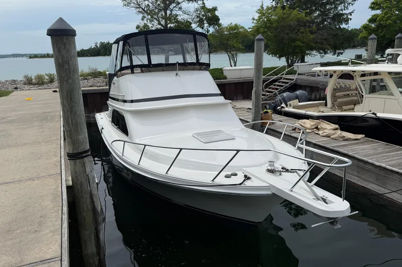 Slide: The Image of 1999 Blackfin 33 Flybridge boat docked at a marina, surrounded by calm waters. - 9