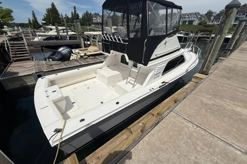 Slide: The Image of 1999 Blackfin 33 Flybridge boat docked at marina, featuring spacious deck and flybridge. - 7