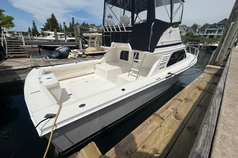Slide: The Image of 1999 Blackfin 33 Flybridge boat docked at a marina, featuring spacious deck and flybridge. - 8