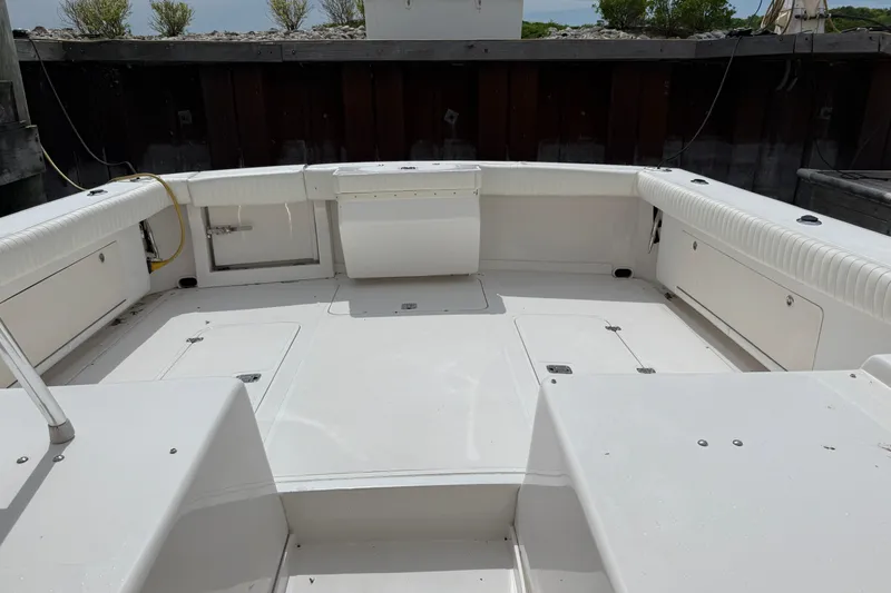 Slide: The Image of Spacious deck of a 1999 Blackfin 33 Flybridge boat, featuring white seating and storage compartments. - 16
