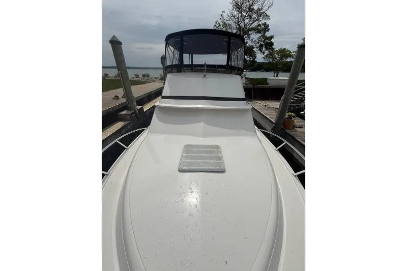 Slide: The Image of 1999 Blackfin 33 Flybridge boat docked, featuring sleek white deck and flybridge. - 19