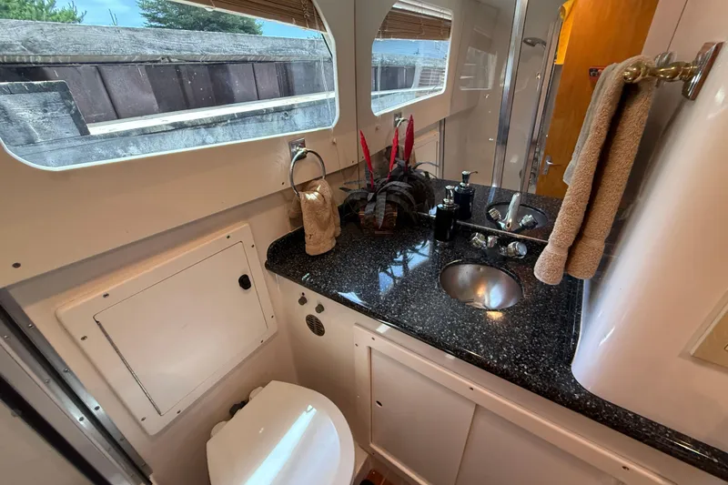 Slide: The Image of 1999 Blackfin 33 Flybridge bathroom with granite countertop, sink, and window view. - 52