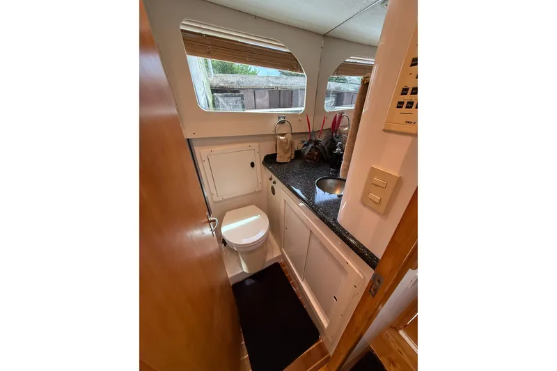 Slide: The Image of 1999 Blackfin 33 Flybridge boat bathroom with sink, toilet, and window. - 51