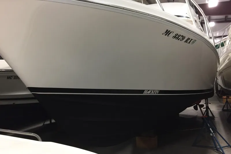 Slide: The Image of 1999 Blackfin 33 Flybridge boat in storage, showcasing sleek hull design. - 57