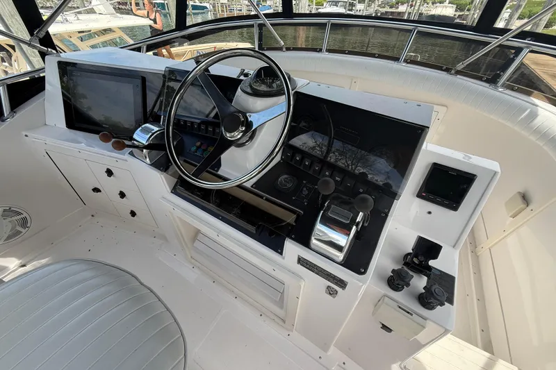 Slide: The Image of 1999 Blackfin 33 Flybridge helm with steering wheel, controls, and navigation equipment. - 23