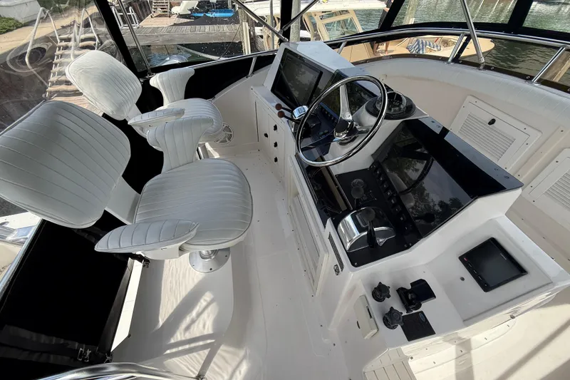 Slide: The Image of Cockpit of 1999 Blackfin 33 Flybridge with white seating and modern controls. - 22