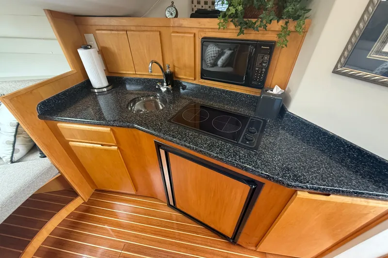 Slide: The Image of Compact kitchen area in a 1999 Blackfin 33 Flybridge boat with modern amenities. - 41