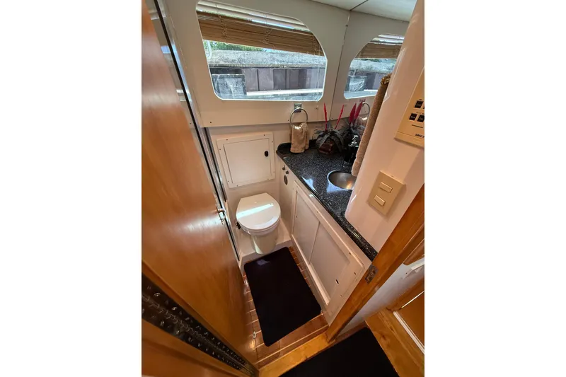 Slide: The Image of 1999 Blackfin 33 Flybridge yacht bathroom with compact design, featuring a toilet and sink. - 50