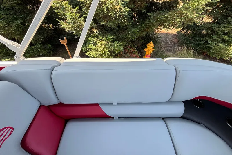 Slide: The Image of 2026 Sun Tracker Party Barge 22 XP3 interior with gray and red seating, near greenery. - 35