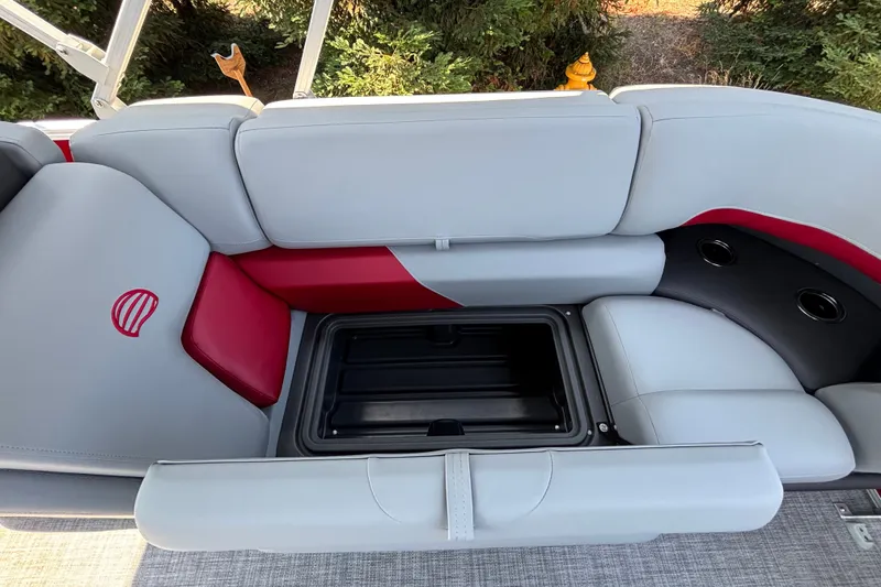 Slide: The Image of 2026 Sun Tracker Party Barge 22 XP3 seating with storage compartment, red and gray upholstery. - 17